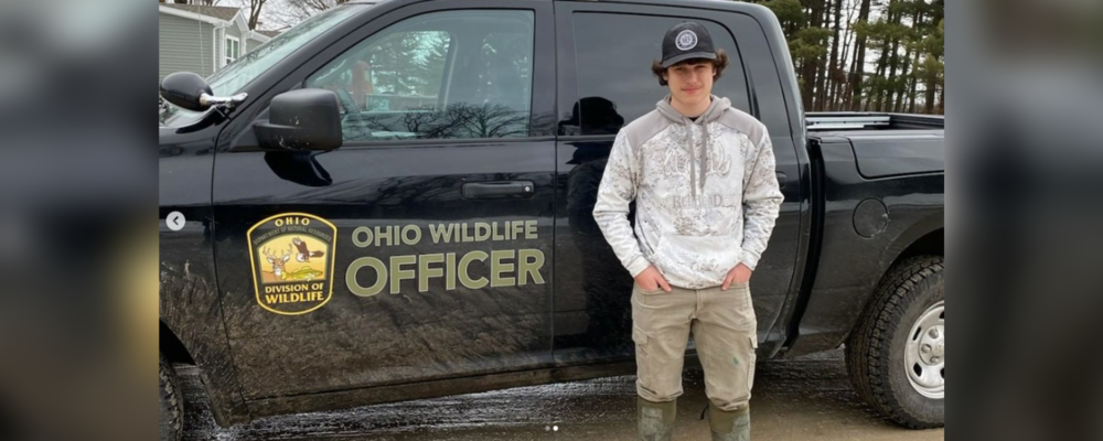Student, Kohen, standing in front of ODNR truck