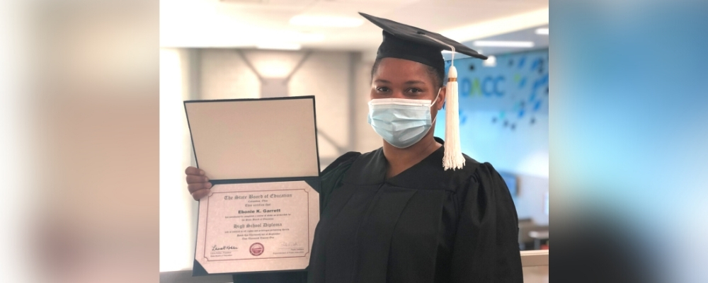 Adult education student holding high school diploma