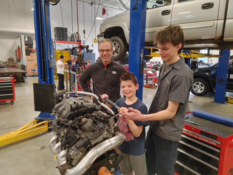 Student posing with engine